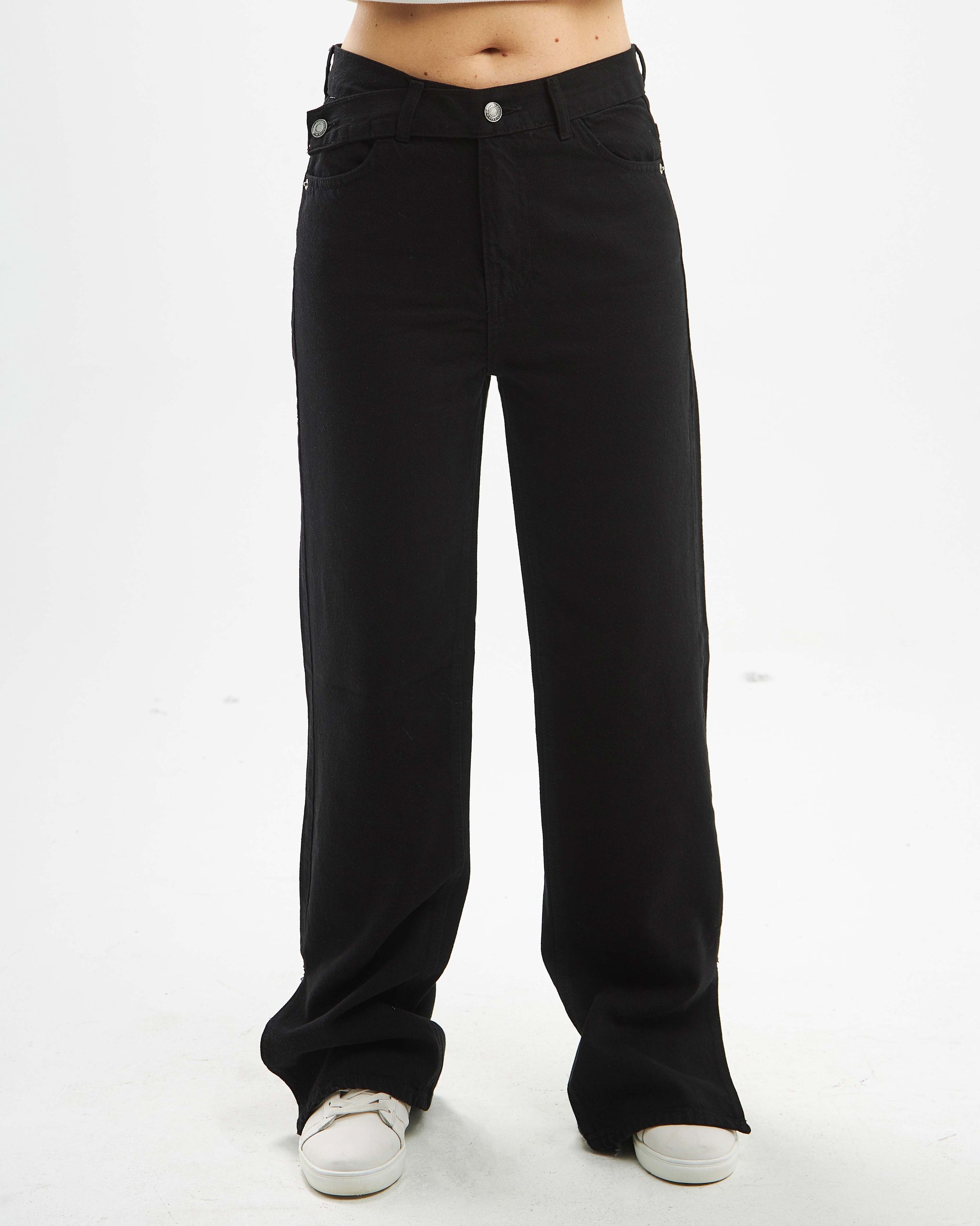 Black straight-leg jeans with a high waist and crossover belt.