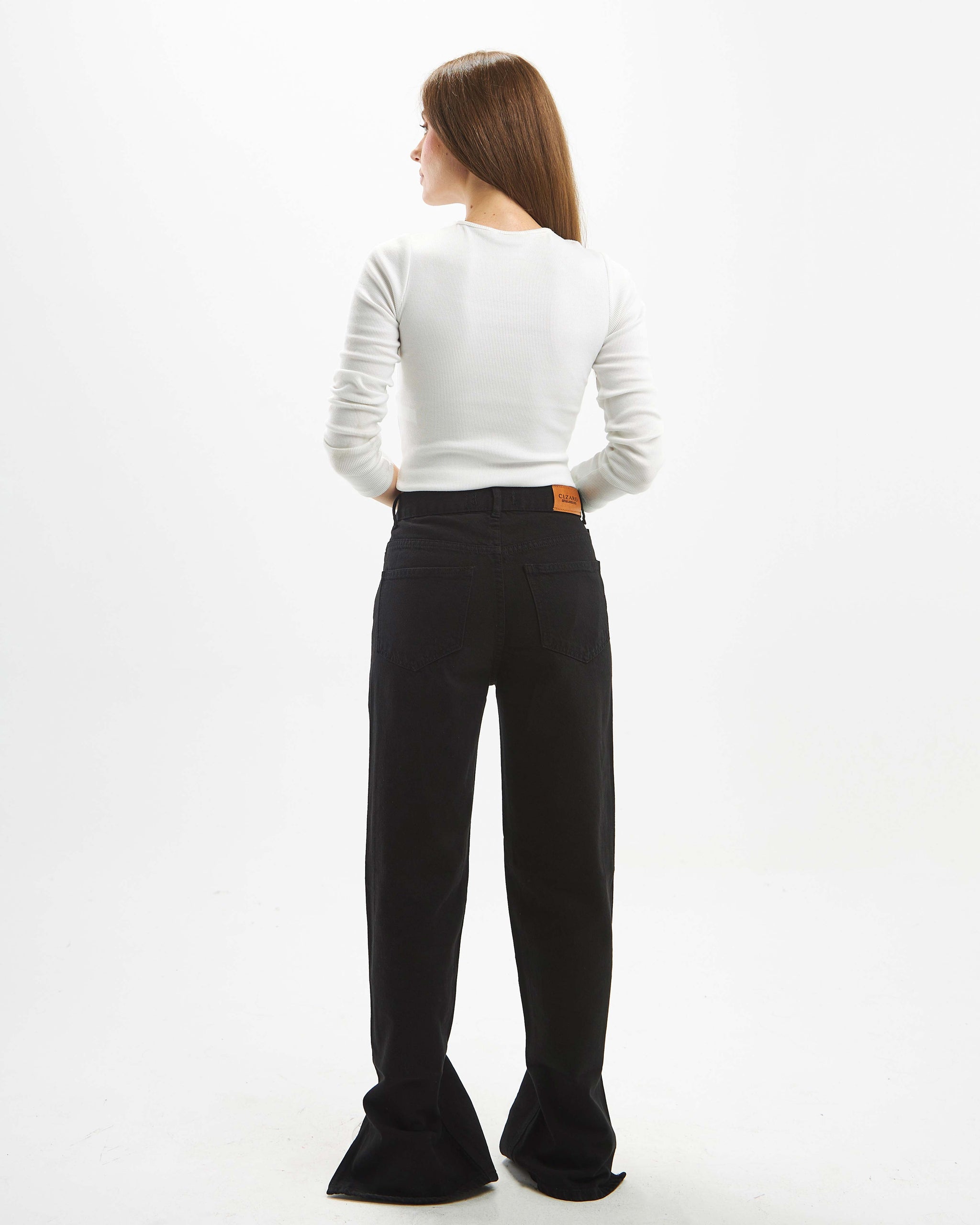 Black straight-leg jeans with a high waist and crossover belt.